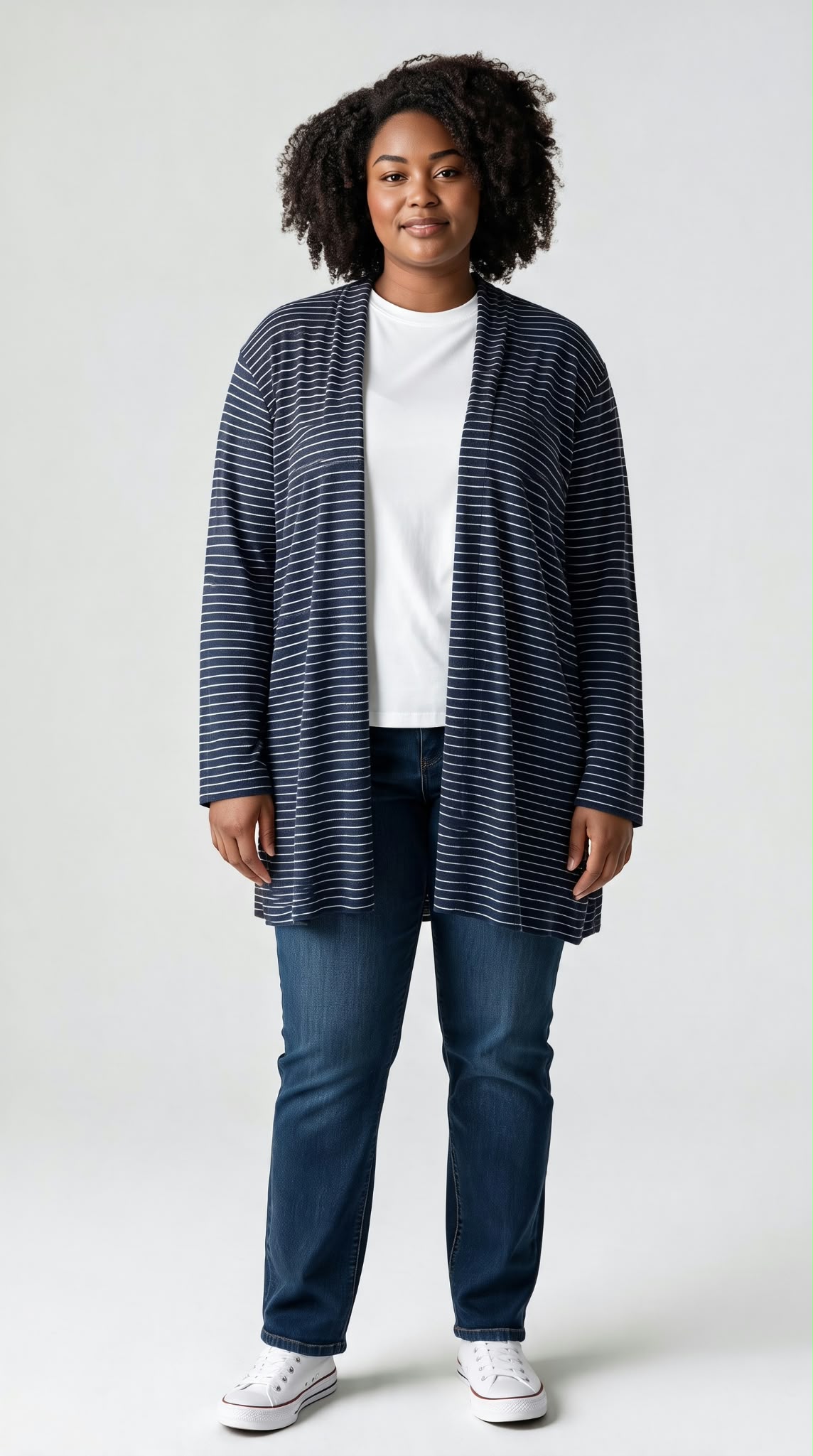 Cárdigan largo de punto fino para mujer con estampado de rayas marineras en azul marino y blanco sobre camiseta y vaqueros.